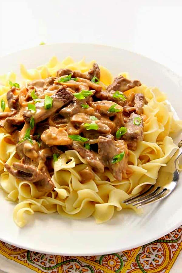 Beef Stroganoff on a white plate with fork.