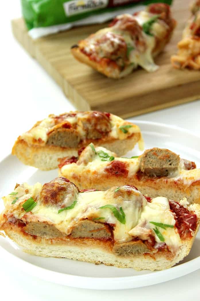 Three slices of meatball sub cheesy bread on white plate.