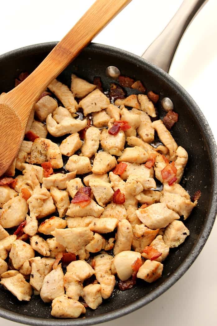 Cooked chicken and bacon in skillet.