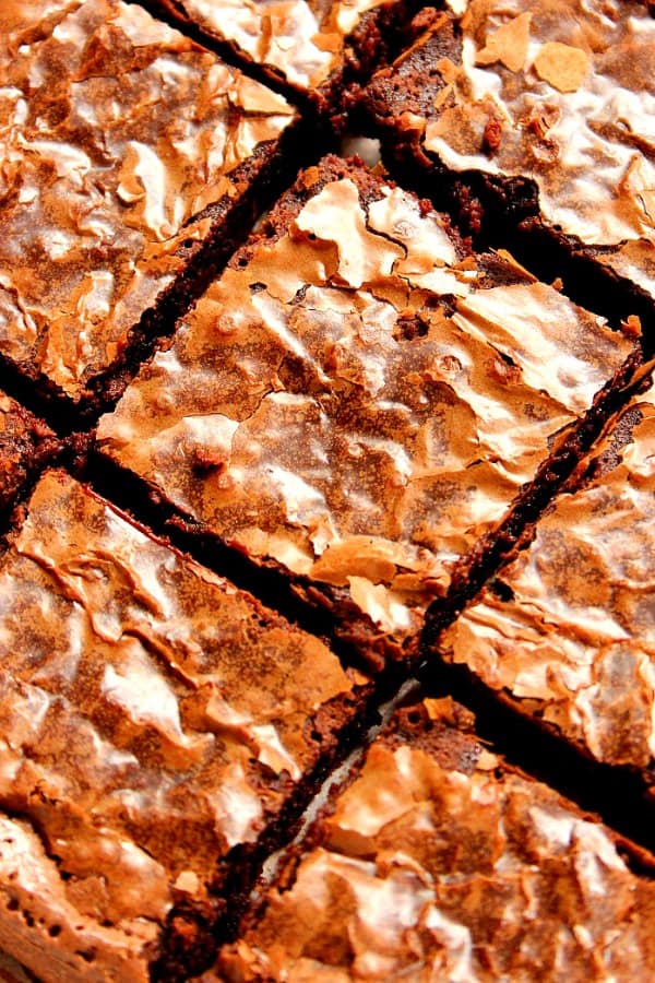 The best, homemade from scratch brownies! They are fudgy with soft, flaky top, melt-in-your-mouth! They taste and look like they were made out of the box mix but are quick, easy and made in one bowl! Overhead shot of cut brownies with flaky top.