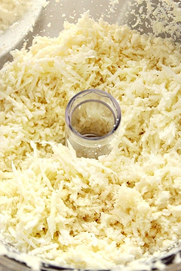 Close up shot of grated cauliflower in food processor.