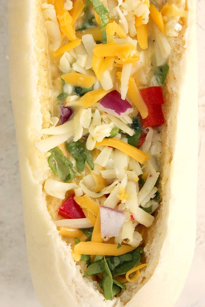 Cheesy Egg Boats recipe - I turned a baguette into a bread boat filled with eggs, cheese and veggies! Perfectly crunchy edges, cheesy filling with lots of flavor from peppers, onions and Monterey Jack cheese. Use Take & Bake baguette for that freshly baked flavor and texture! 