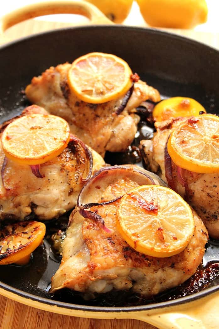 Four roasted chicken thighs in pan.