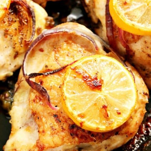 Lemon garlic roasted chicken thighs in cast iron skillet.