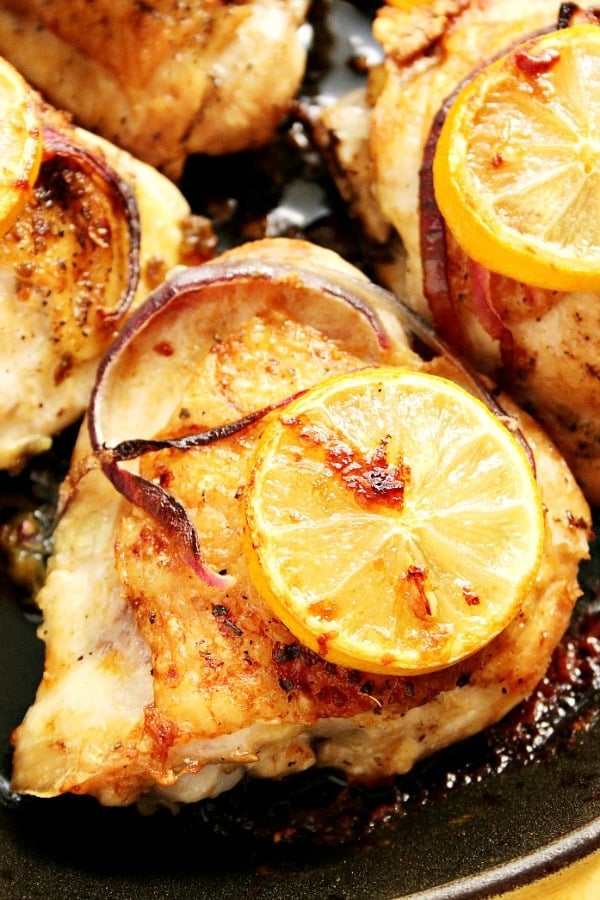 Lemon garlic roasted chicken thighs in cast iron skillet.