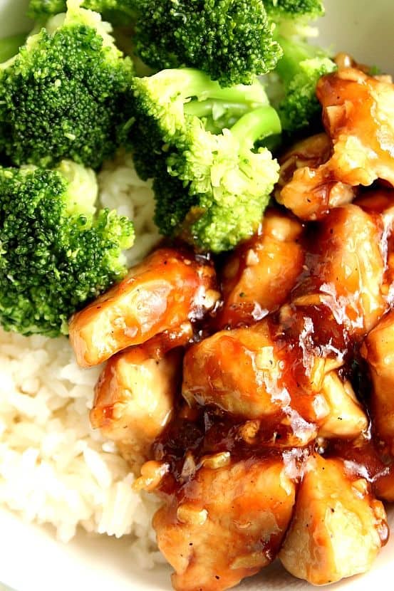 Close up shot of teriyaki chicken with rice and broccoli.