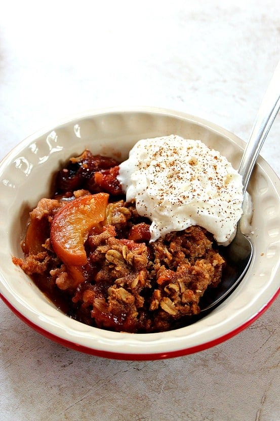 Slow Cooker Peach Crisp recipe - sweet peaches, sliced and tossed with vanilla, baked under oats and brown sugar topping that tastes just like oatmeal cookies! This is my favorite crock pot dessert for hot summer days! Served with whipped cream or vanilla ice cream.