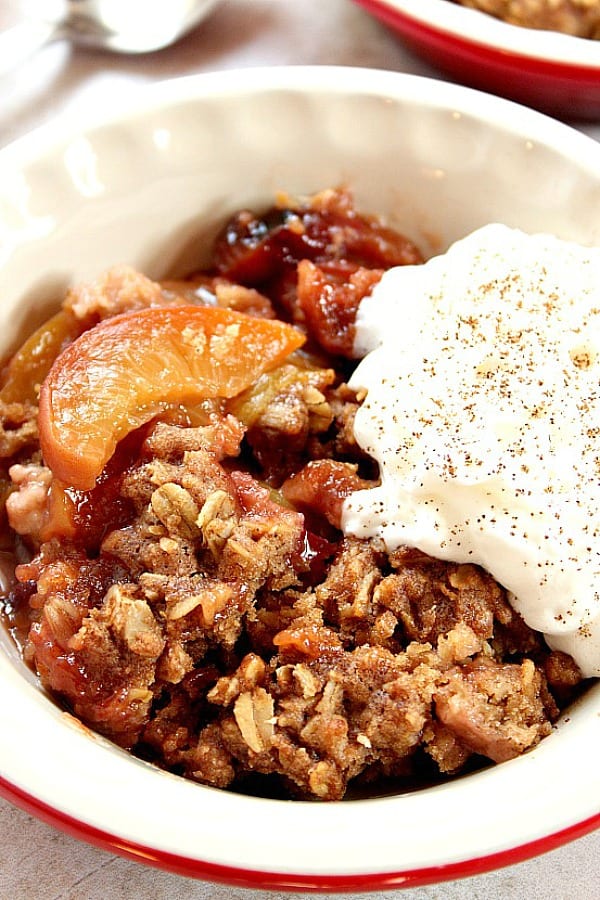 Slow Cooker Peach Crisp recipe - sweet peaches, sliced and tossed with vanilla, baked under oats and brown sugar topping that tastes just like oatmeal cookies! This is my favorite crock pot dessert for hot summer days! Served with whipped cream or vanilla ice cream. Slow Cooker Peach Crisp in a bowl with ice cream.