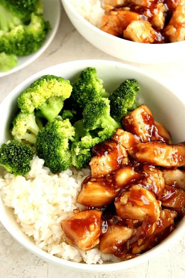 Teriyaki chicken, rice and broccoli in a white bowl on a gray board.