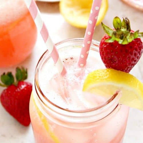 Strawberry lemonade in a glass jar with straws.