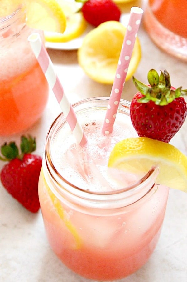 Strawberry lemonade in glass jar with straws.