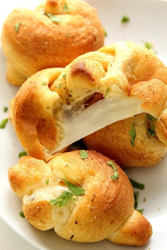 Stuffed Garlic Knots recipe - a restaurant copycat that is crazy easy to make at home! Cheese stuffed garlic knots dipped in Parmesan garlic butter are perfect for a movie night, party or a get-together. 