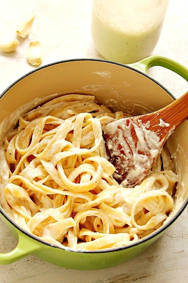 Overhead shot of fettuccine with Alfredo sauce in saucepan.