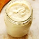 White pasta sauce in glass jar without lid.