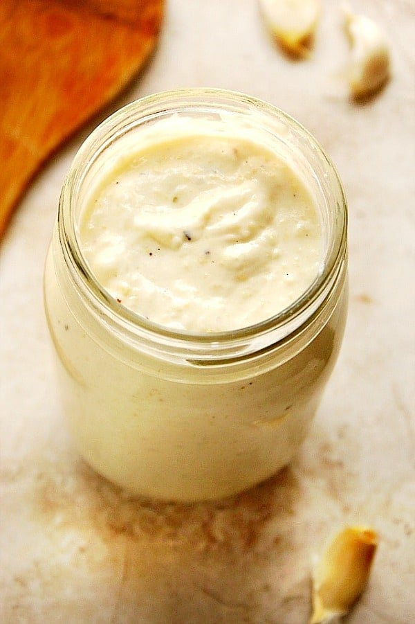 Overhead shot of white pasta sauce in glass jar.