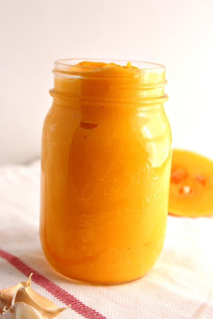 Side shot of butternut squash Alfredo sauce in glass jar.