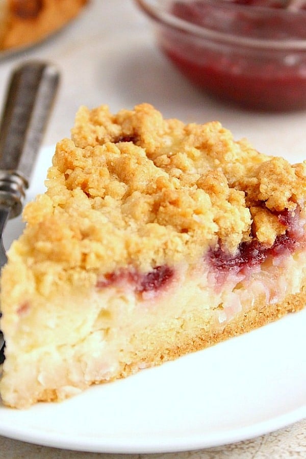 Raspberry Coconut Sour Cream Crumb Pie Recipe - sweet and creamy coconut filling with a tarty raspberry jam, all under a buttery crunchy crumb topping. This pie is easy and absolutely delicious! Raspberry Coconut Sour Cream Crumb Pie slice on a plate.
