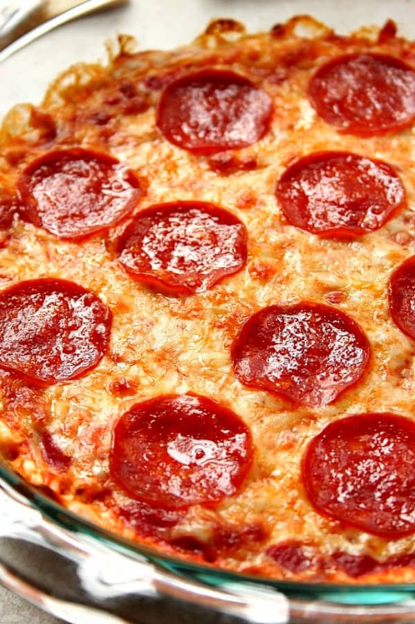 Close up shot of pepperoni pizza dip in glass dish.