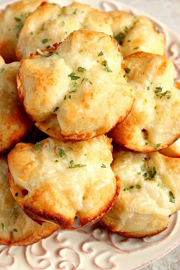 Garlic Parmesan Pull-Apart Rolls Recipe Rolls stacked up on white plate.