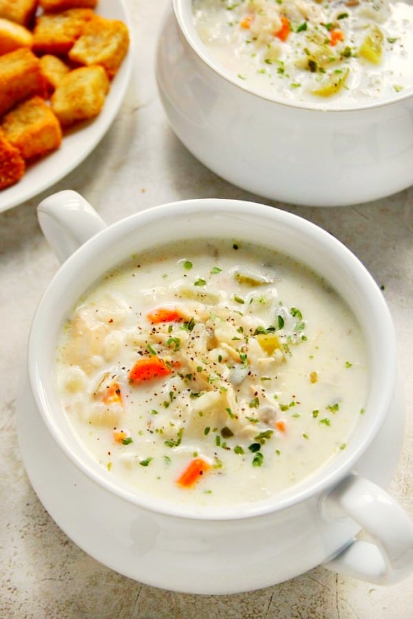 Slow Cooker Chicken Wild Rice Soup Recipe - creamy and filling soup with chicken, wild rice and vegetables. Quick to prepare and cook in your slow cooker! Slow Cooker Chicken Wild Rice Soup in a soup bowl with handles.
