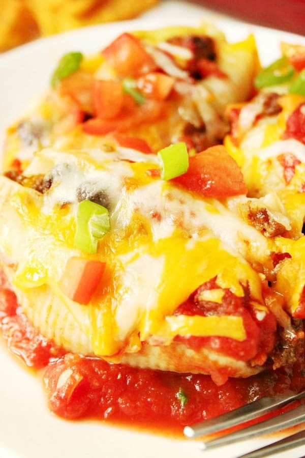 Taco stuffed pasta shells on a plate.