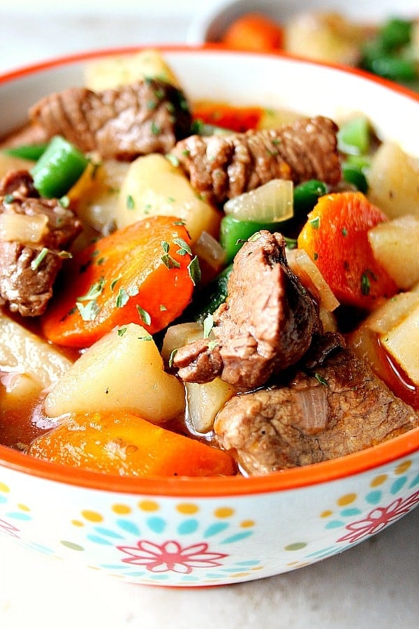 Close up shot of beef stew with carrots and potatoes in a soup bowl.