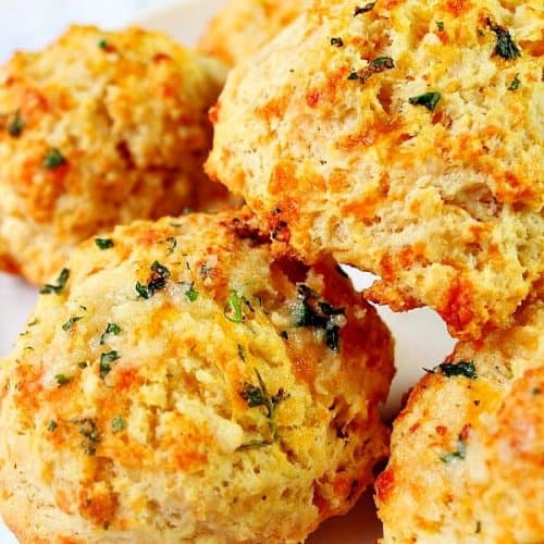 Cheddar Bay Biscuits stacked on a white plate.