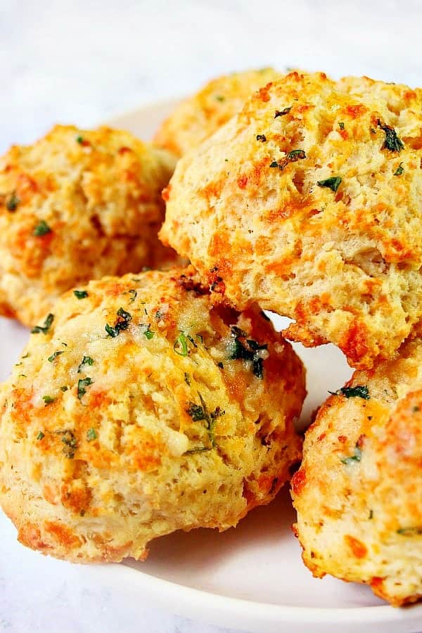 Cheddar Bay Biscuits stacked on a white plate.