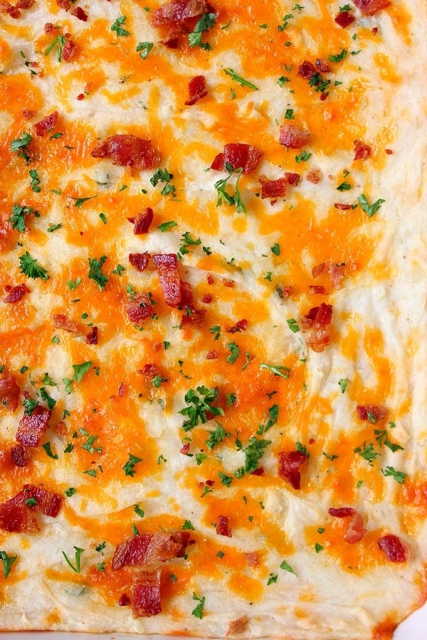 Mashed Potato Casserole Recipe - the best creamy mashed potatoes baked into a cheesy casserole with bacon! Great made ahead as well! Casserole with cheddar and bacon on top.