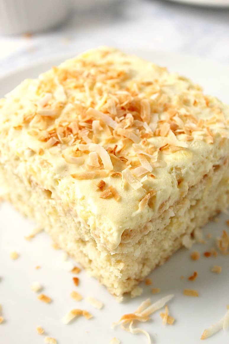 slice of pineapple cake with coconut frosting on a plate