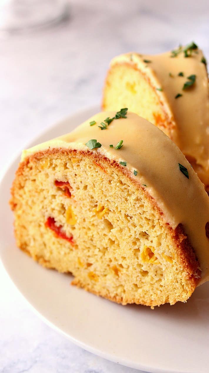 Close up shot of one cornbread bundt cake slice on white plate.