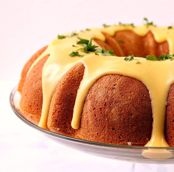 Side shot of cornbread bundt cake with golden nacho cheese sauce.