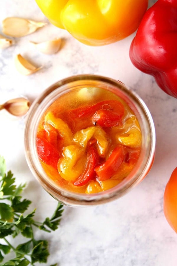 Marinated roasted red peppers in a jar.
