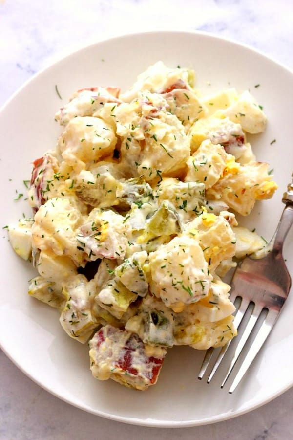 Dill Pickle Potato Salad on white plate with fork.