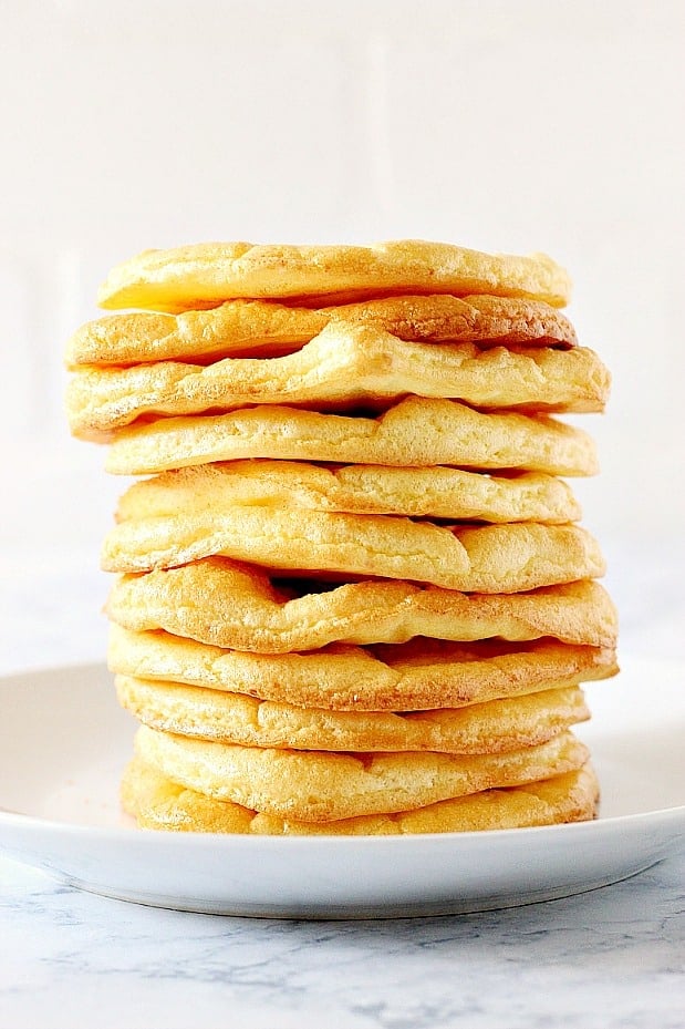 Side shot of cloud bread slices in a stack on white plate.