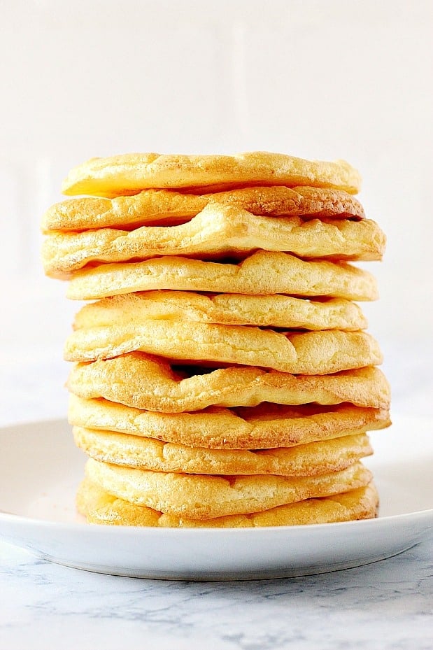 Cloud Bread Recipe - low-carb, high-protein, gluten-free substitute for bread, made with just 3 ingredients. Great for keto diet. Side shot of cloud bread slices in a stack on white plate.