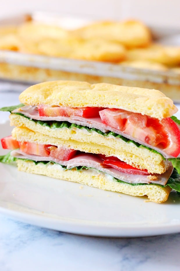 Side shot of cloud bread sandwich with tomatoes, ham and lettuce.