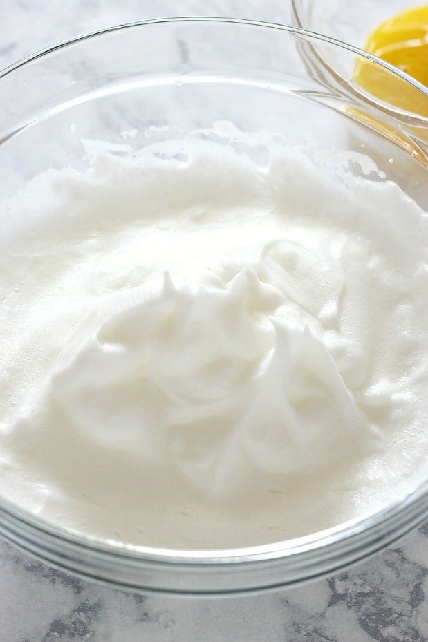 Overhead shot of whipped egg whites in glass bowl.