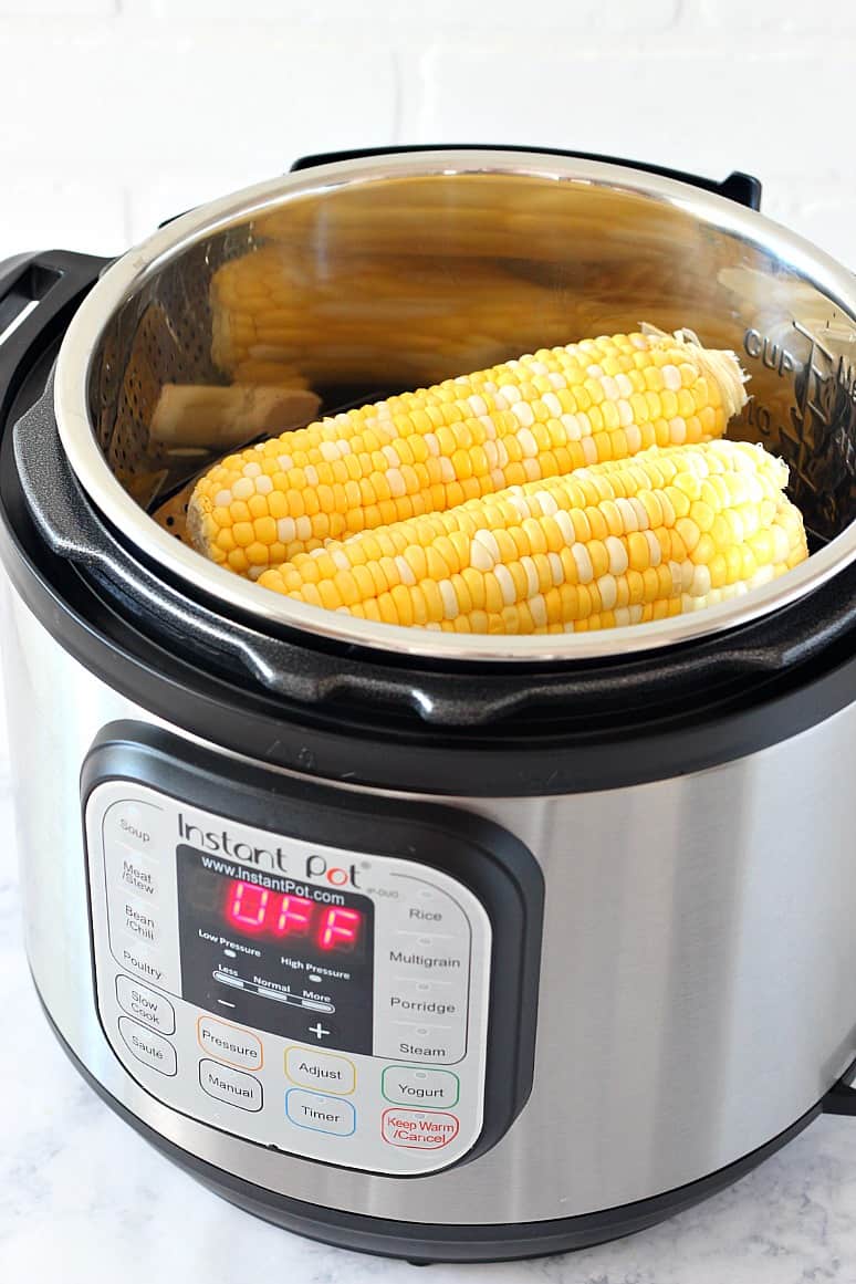 Side shot of corn on the cob placed inside Instant Pot. 