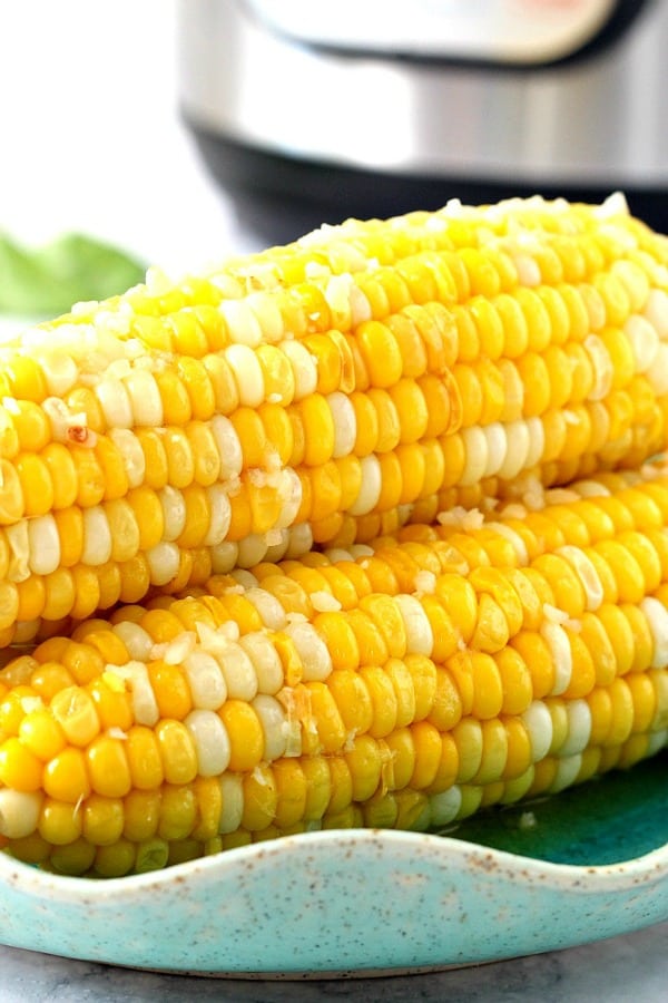 Instant Pot Garlic Parmesan Corn on the Cob Recipe - the best and the fastest method to cook corn on the cob. Brushed with garlic Parmesan butter, this corn on the cob is the perfect summer side dish! Instant Pot Corn on the Cob on a plate.
