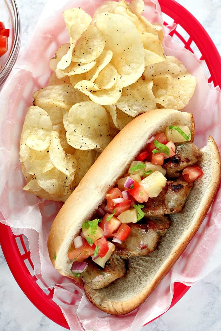 Grilled Chicken Sausage with Pineapple Salsa Recipe - spiral cut grilled sausage is paired with fresh, sweet and savory topping of pineapple, tomatoes, red onion and bell pepper. Perfect Summer picnic food!