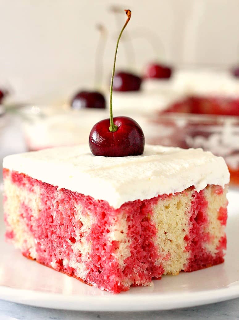 Cherry Poke Cake Recipe - fluffy vanilla cake with dark cherry jello, topped with whipped cream topping and fresh sweet cherries. This is the one summer dessert you have to try! 