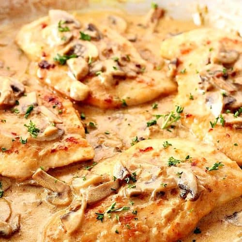 Creamy Mushroom Garlic Chicken cutlets in a pan with sauce.