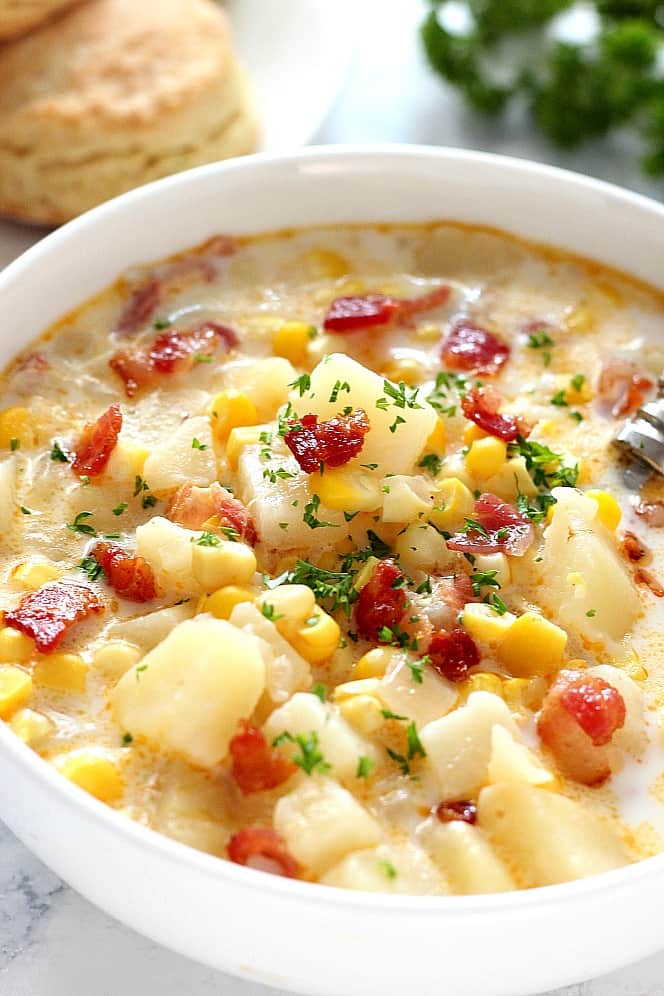 Close up shot of Instant Pot corn chowder with bacon in white bowl.