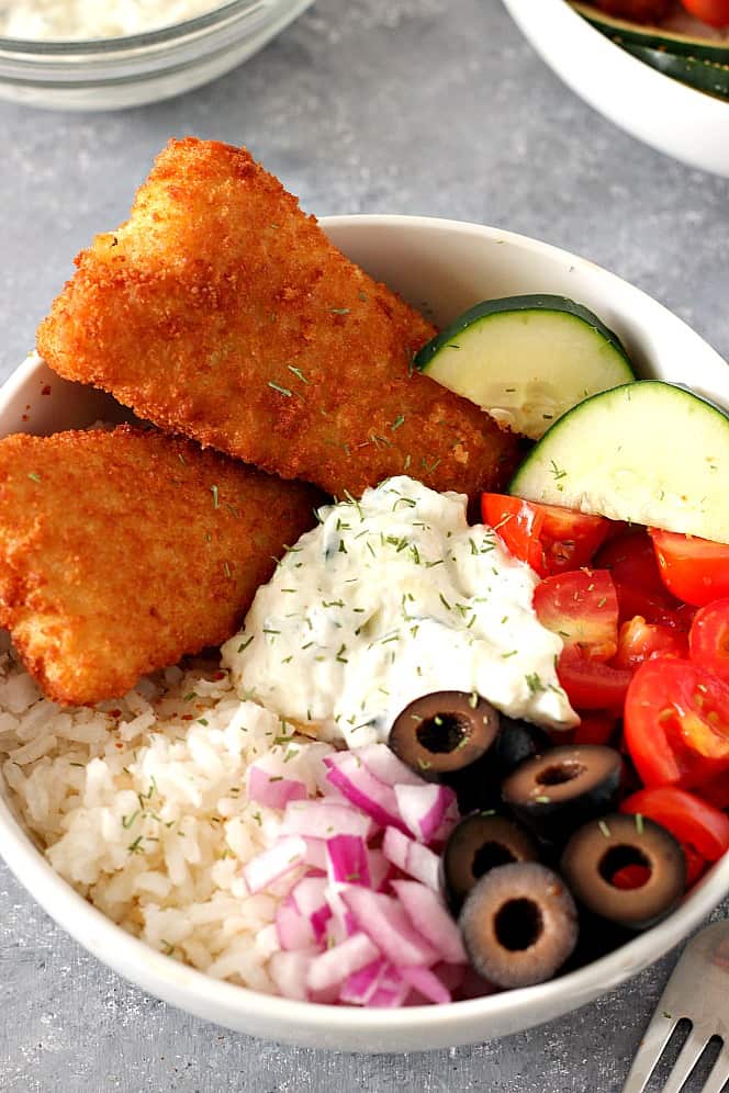 Crispy Fish Greek Rice Bowls Recipe - chopped vegetables, cucumber dill sauce and rice served with breaded fish fillets are a delicious lunch or dinner idea for busy weekdays. 