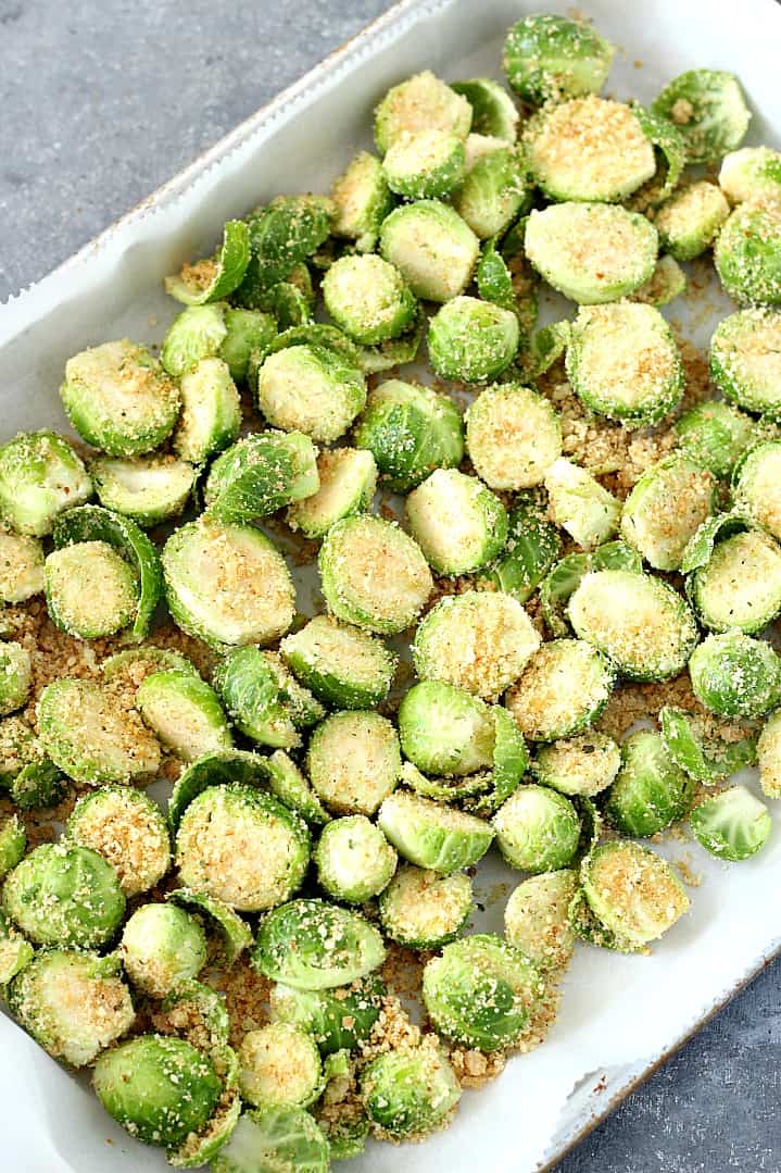 Brussels sprouts with breading on baking sheet.