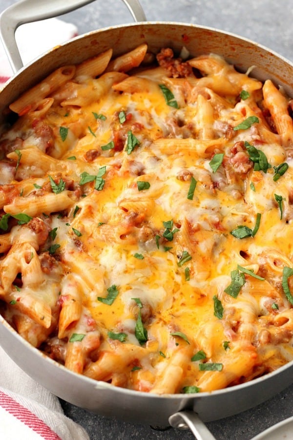 One Pot Cheesy Sausage Penne Recipe - hearty and satisfying one pan pasta dinner. Italian sausage, quick tomato sauce and penne pasta with cheesy topping is perfect for busy weeknights. Cheesy Sausage Penne in pot.