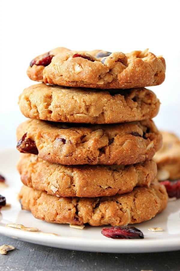 Flourless Peanut Butter Oatmeal Cookies stacked up on each other on white plate.