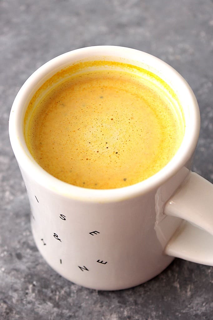 Golden Milk Latte Recipe - delicious immune-boosting drink with turmeric, cinnamon, ginger and your choice of milk. Golden Milk Latte in white mug.