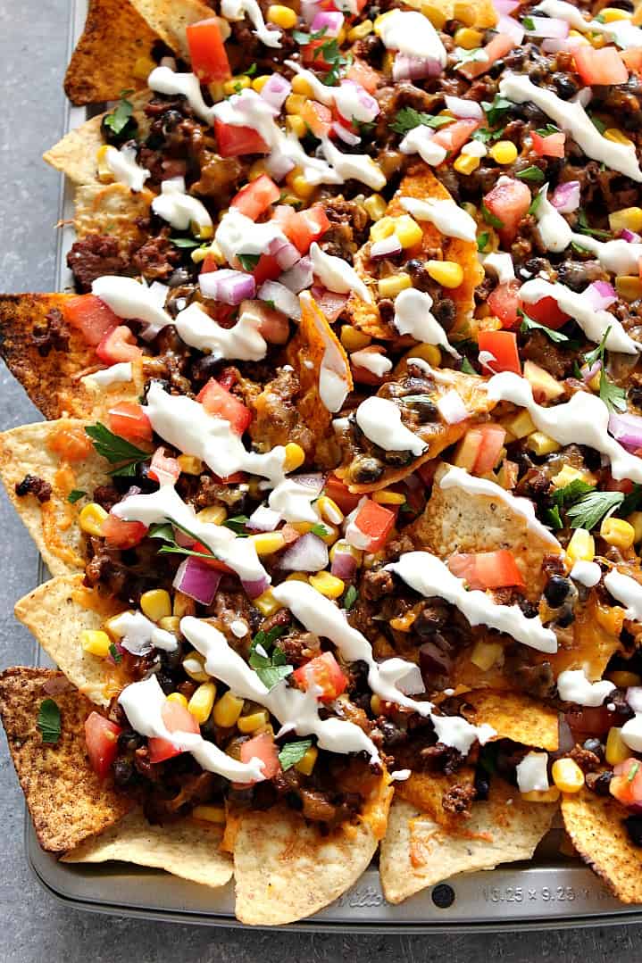 Sheet Pan Nachos Recipe - loaded nachos with all of your favorite toppings and baked in the oven. www.crunchycreamysweet.com Nachos on a sheet pan.